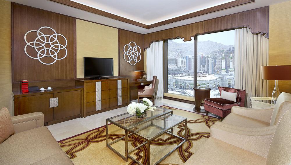 Jabal Omar Marriott Hotel Makkah La Meca Exterior foto The photo shows a luxurious hotel room or living area. It features elegant furnishings, including a sofa, a coffee table with a decorative pattern, and a comfortable armchair. A large window provides a view of the outside landscape, which appears to 