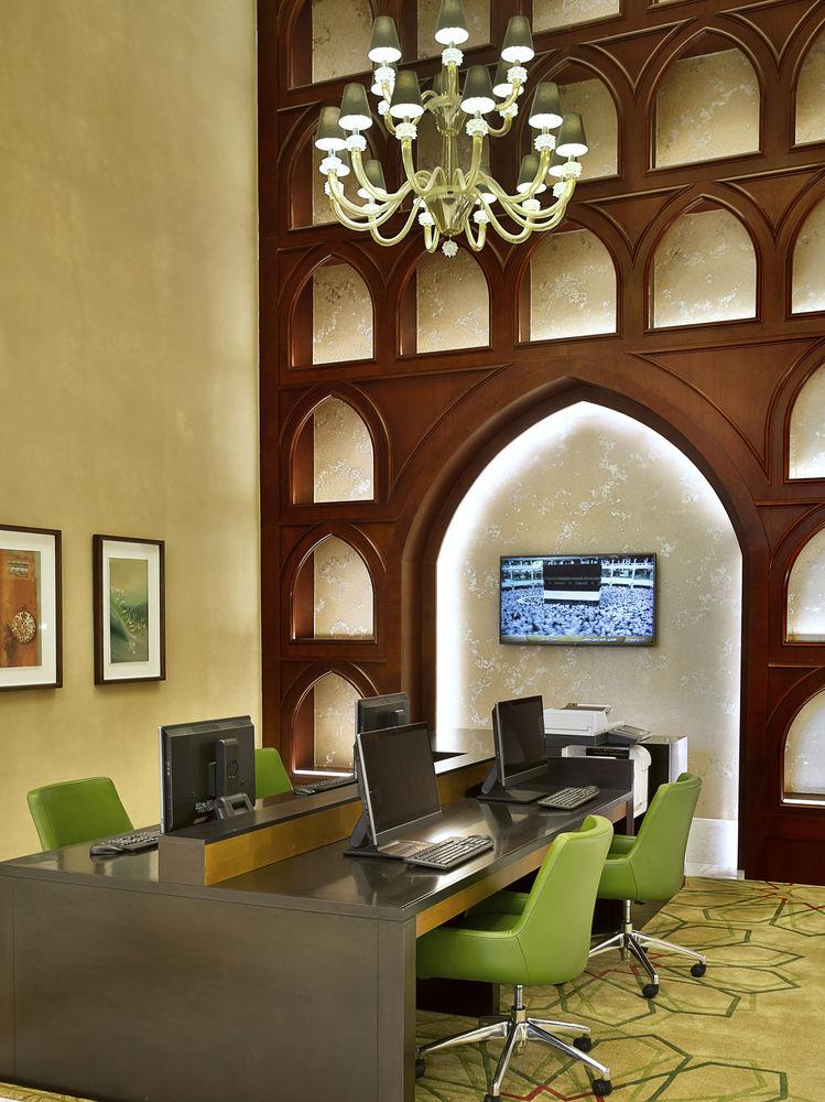 Jabal Omar Marriott Hotel Makkah La Meca Exterior foto The photo depicts a modern office or workspace with a blend of contemporary and traditional design elements. It features a wooden wall with an arch and decorative cutouts, creating an inviting atmosphere. There are multiple workstations equipped with