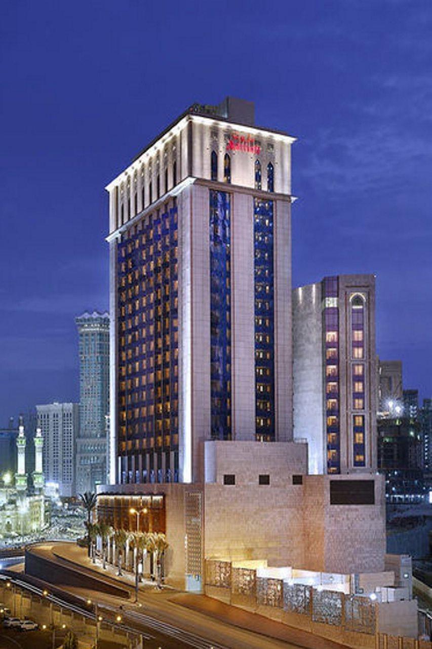 Jabal Omar Marriott Hotel Makkah La Meca Exterior foto The photo shows a tall, modern building, likely a hotel or commercial structure, illuminated at night. The architecture features a combination of glass and concrete, with a prominent vertical design. The upper part of the building has a distinctive, 